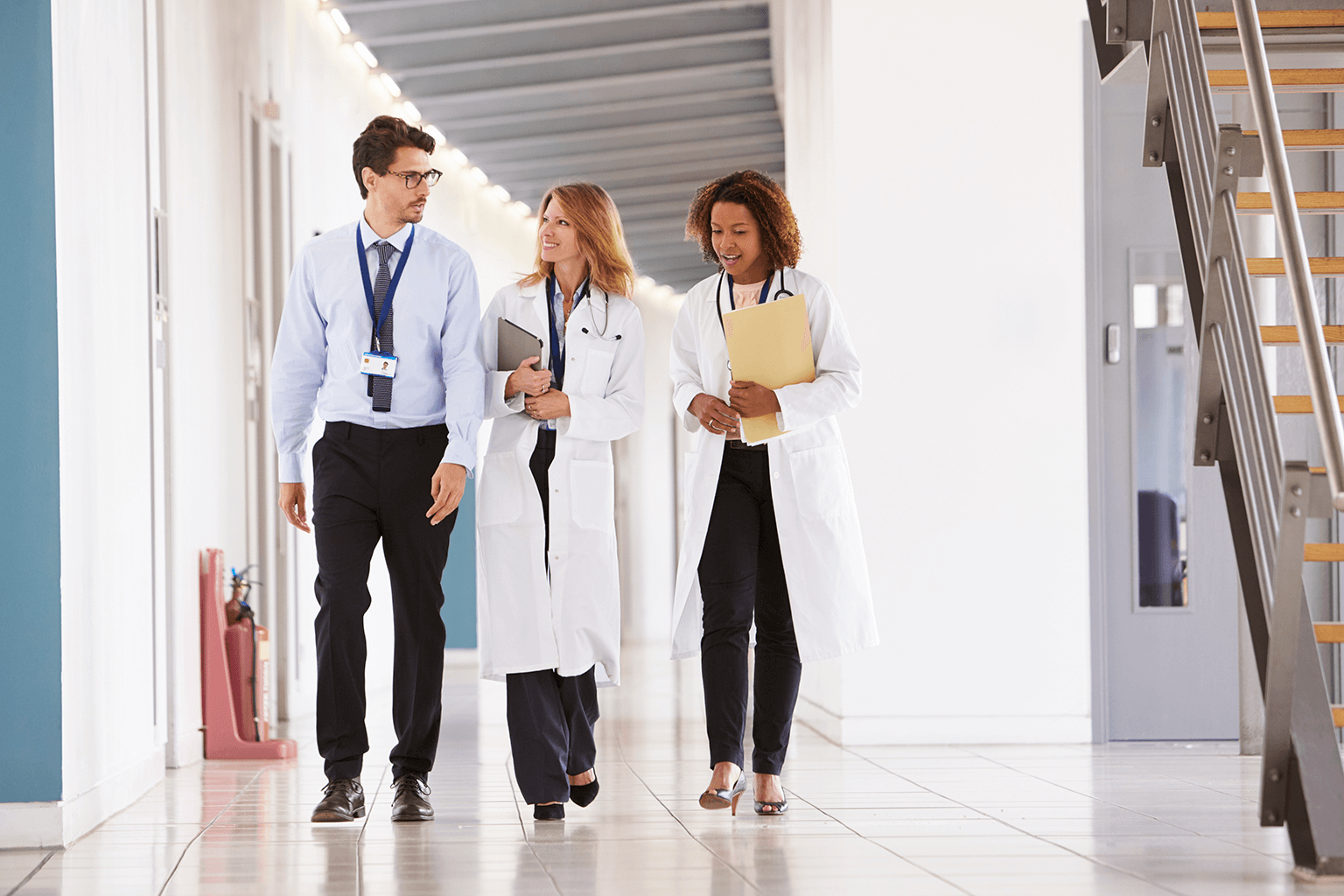 clinicians-walking-down-hallway-in-hospital