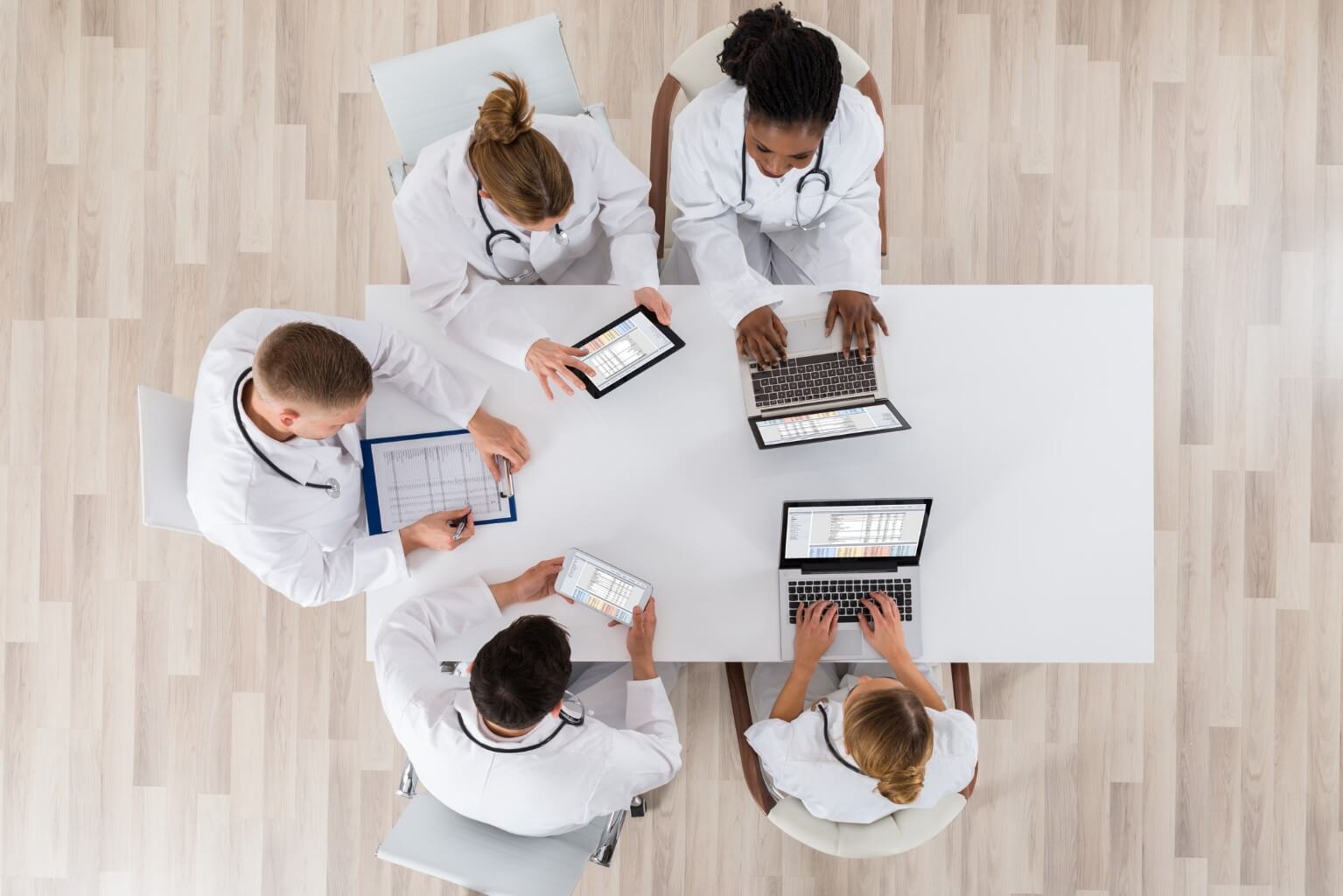 HL-Insights High-Angle-View-Of-Doctors-With-Laptop-And-Digital-Tablet-In-Meeting