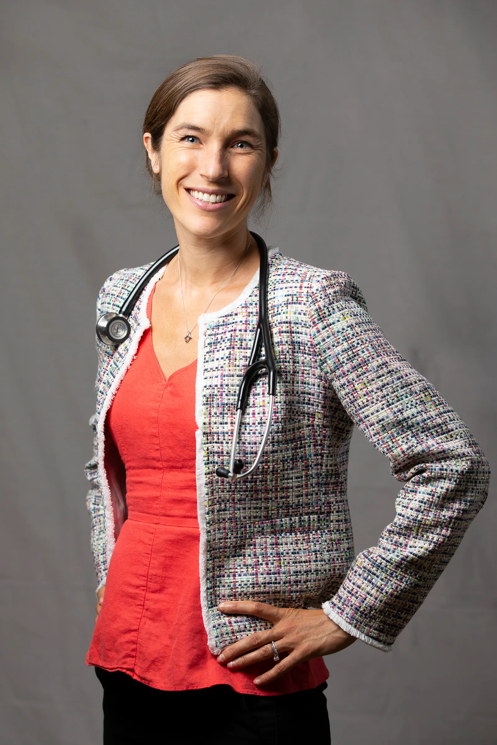 Dr. Wakeman wearing orange shirt with textured blazer, stethoscope worn on neck