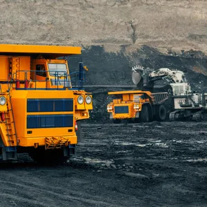 A large quarry dump truck in a coal mine. Loading coal into body work truck. Mining equipment for the transportation of minerals.