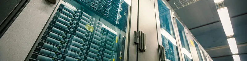 Abstract of modern high tech internet data center room with rows of racks with network and server hardware.