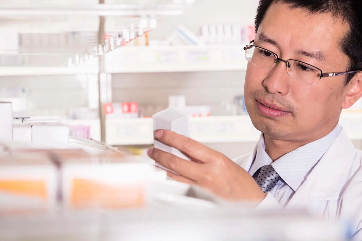 pharmacist examining medication in pharmacy