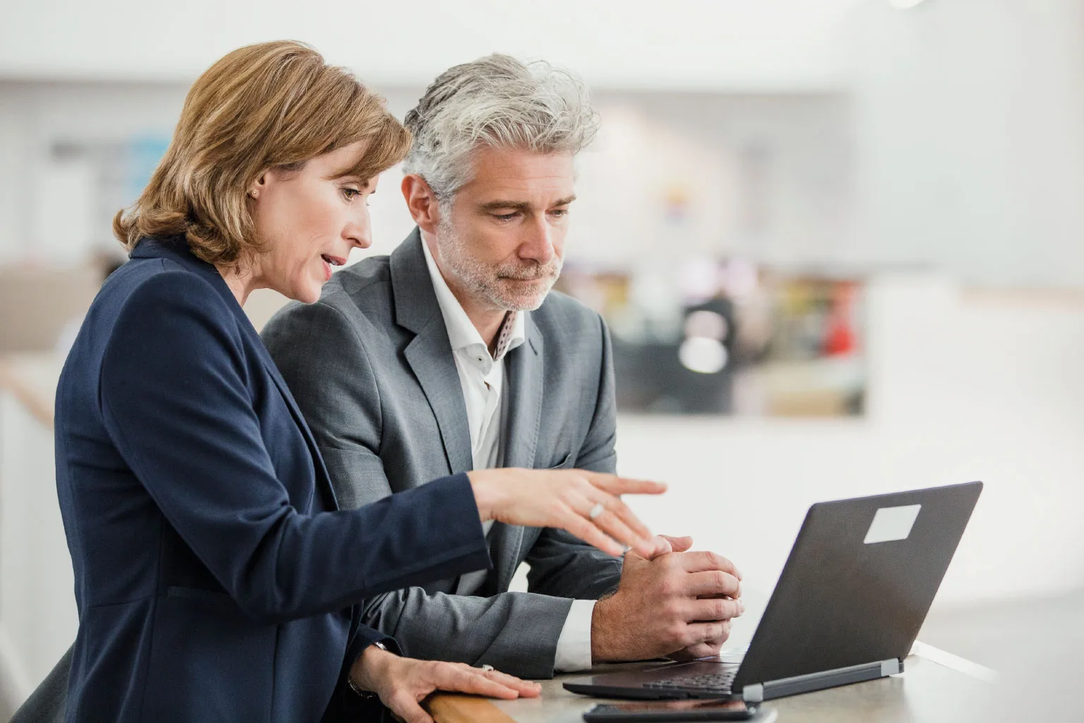 two people looking at a laptop
